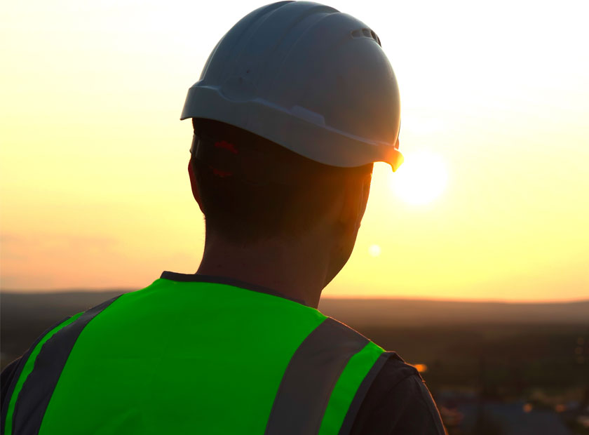 construction worker with hard hat watching the sunset